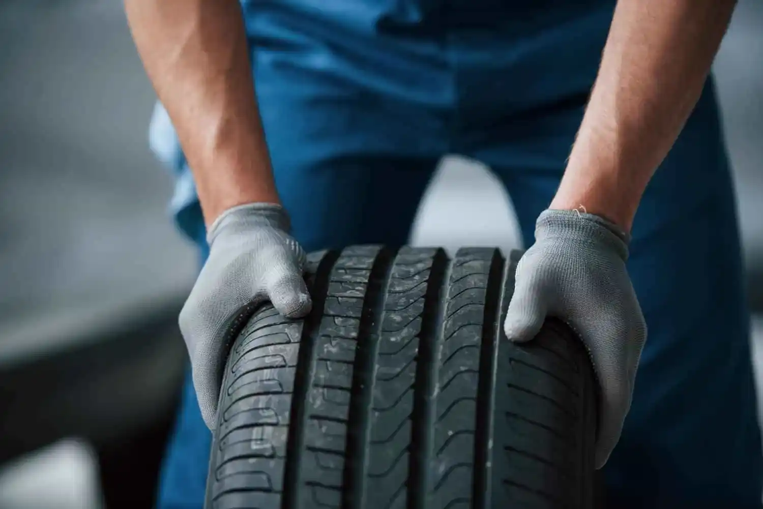 Technician carrying a replacement tyre